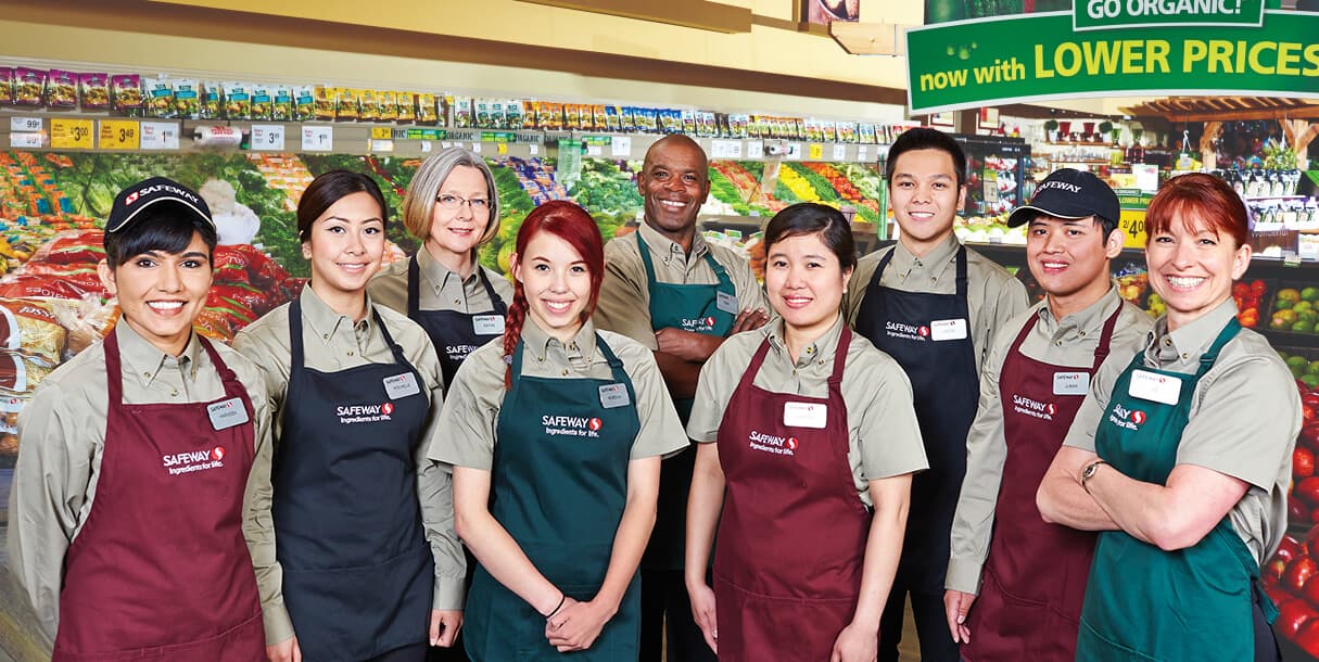 An Image of a group of Safeway workers standing and representing Safeway supermarket store with a smiling face.