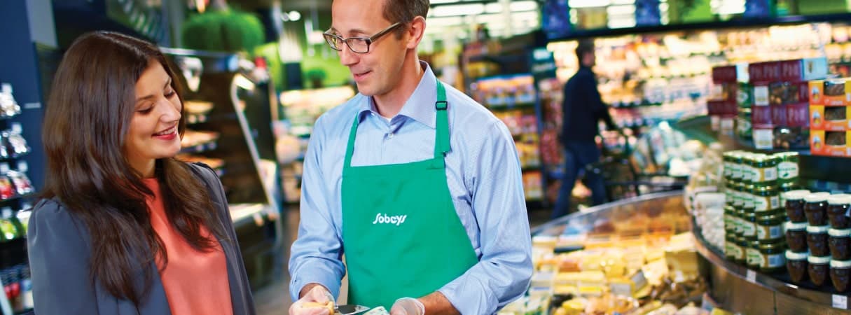 An image with a Sobeys worker assisting his customer