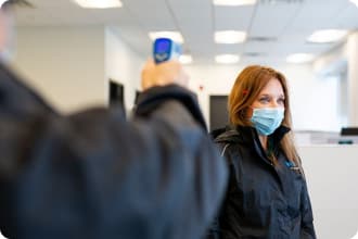 At the Customer Fulfilment Centre, a Voilà by Sobeys delivery teammate gets their temperature checked by a colleague.